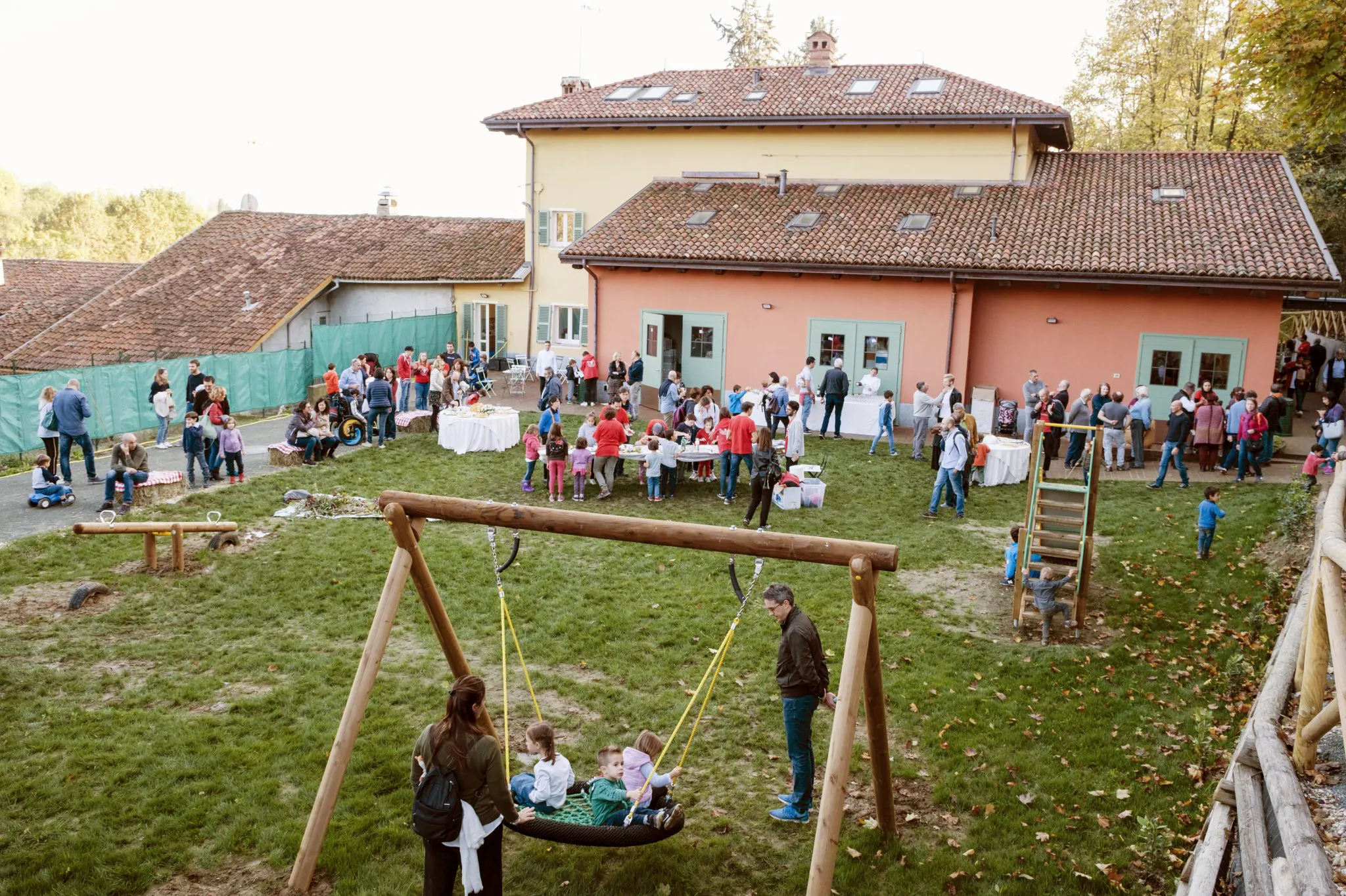 molte persone, tra cui tanti bambini, in un parco giochi