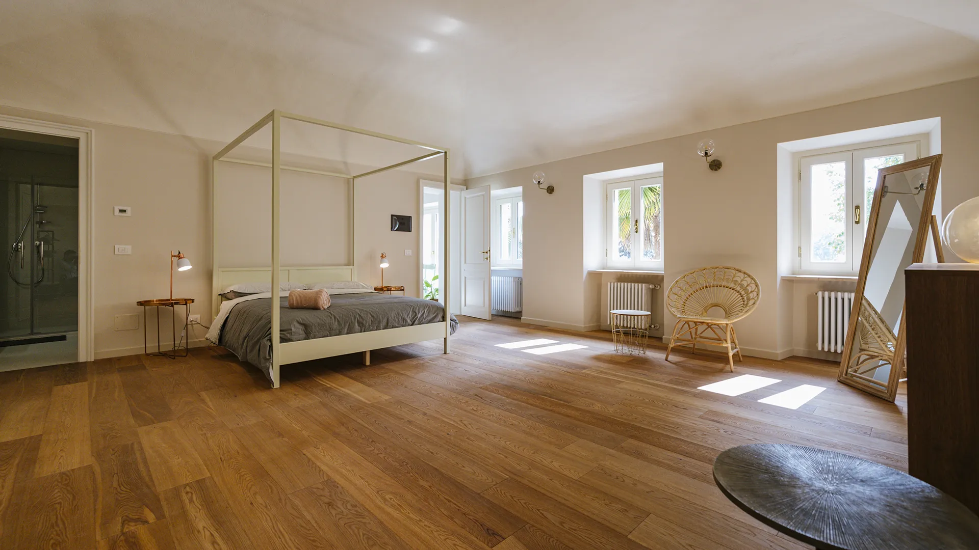 stanza matrimoniale luminosa e dai colori chiari, con un letto e altri arredi