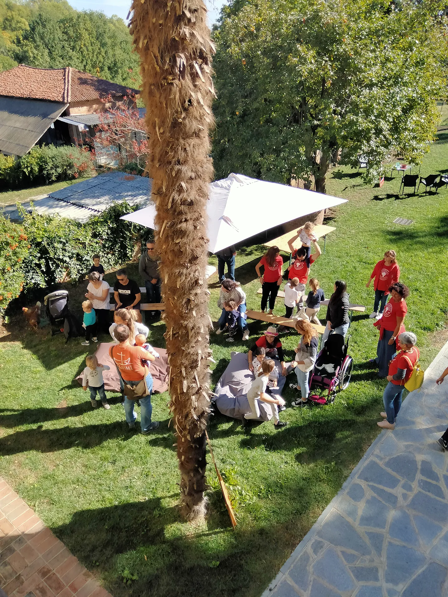 veduta dall'alto di un gruppo di persone che gioca e chiacchiera in un prato